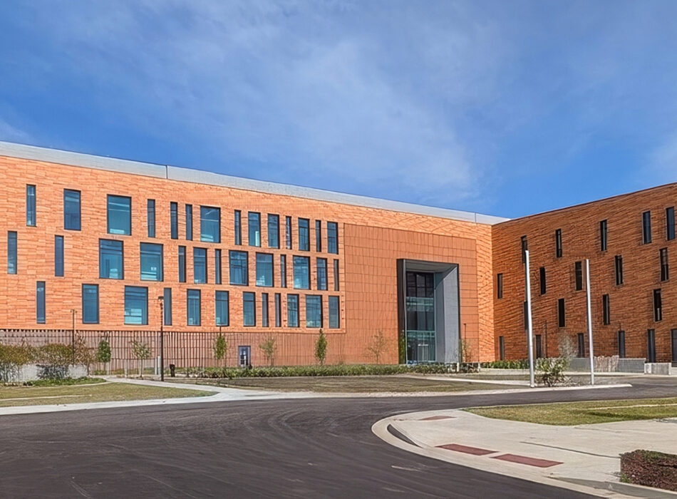 Modern orange-brick building with irregular windows and central entrance.