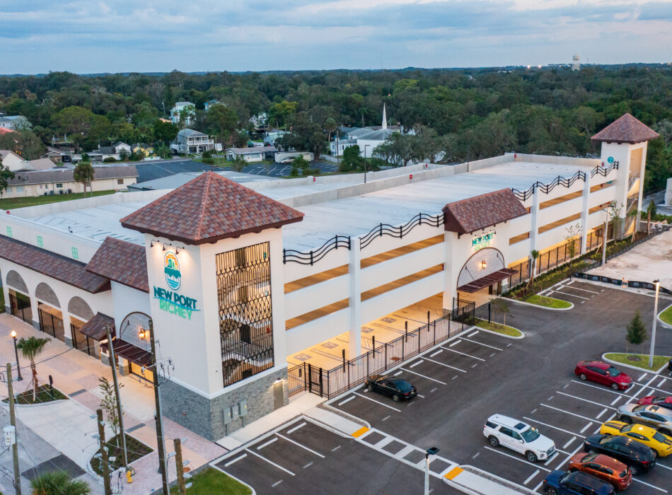 Mediterranean-style parking garage labeled NEW PORT, suburban setting.