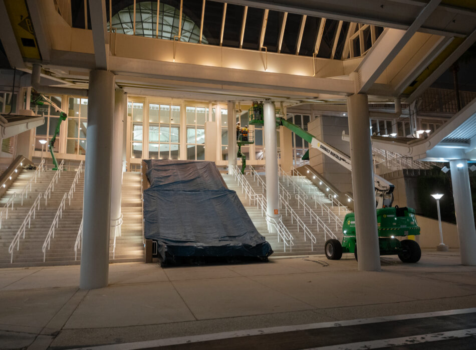 Staircase with tarp, two green lifts, lit at night.