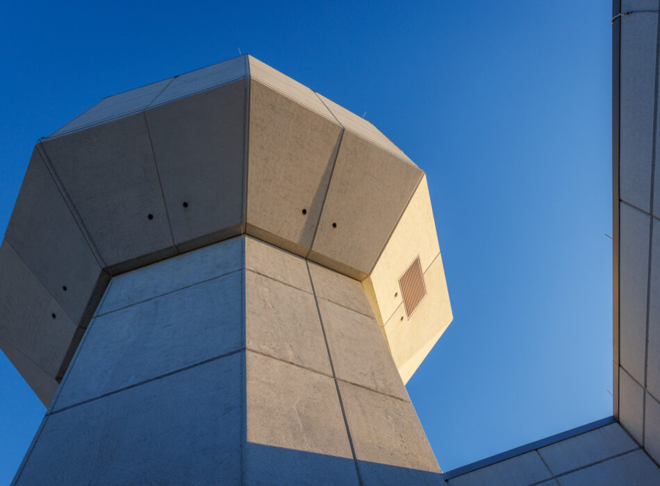 Geometric concrete structure with sharp angles under blue sky.