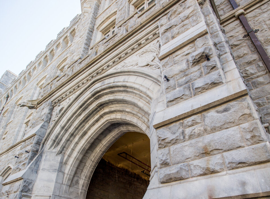Stone archway to Pershing Barracks with metal sign.