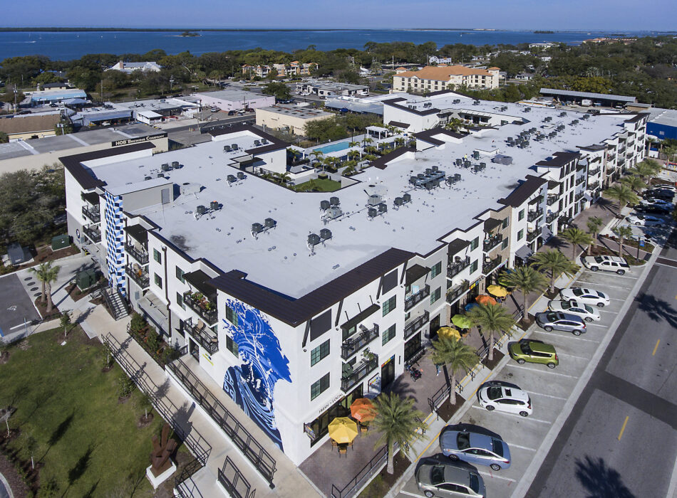 Aerial view of modern apartments by a bay.