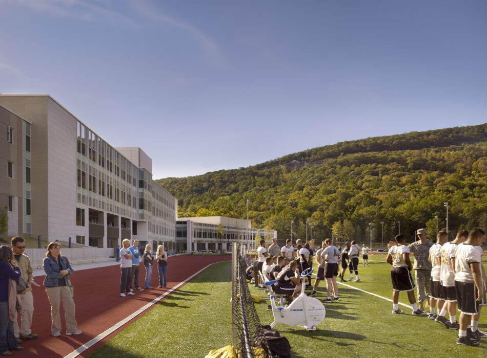 People gather and exercise on a sunny school field.