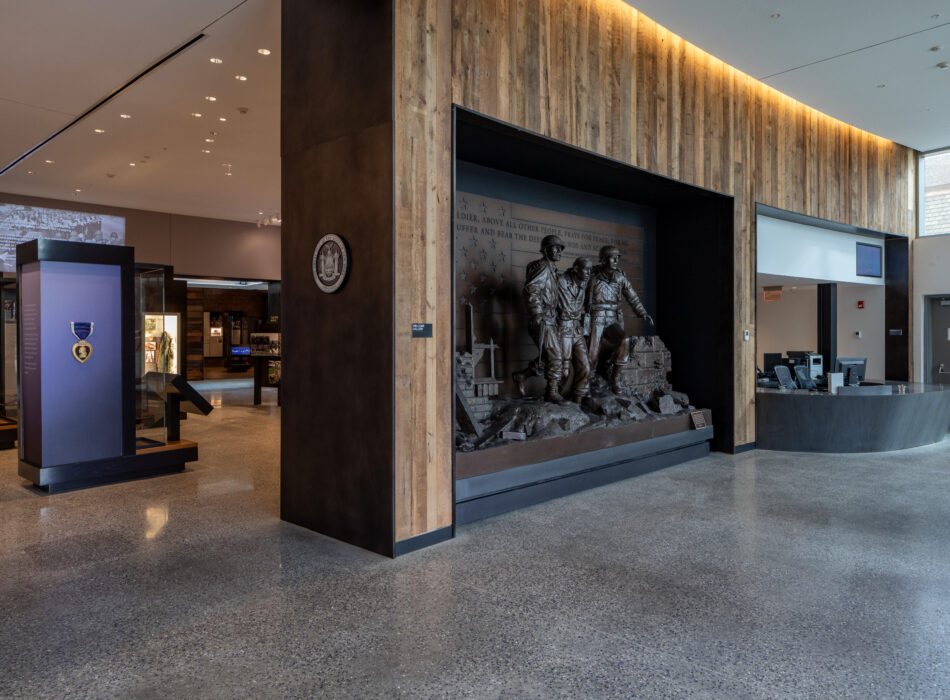 Museum interior with bronze soldiers, reception desk, Purple Heart display.
