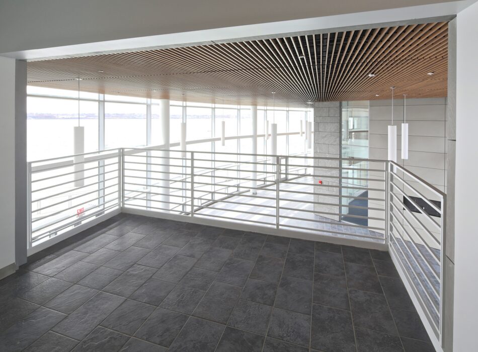 Modern balcony with metal railing and water view.