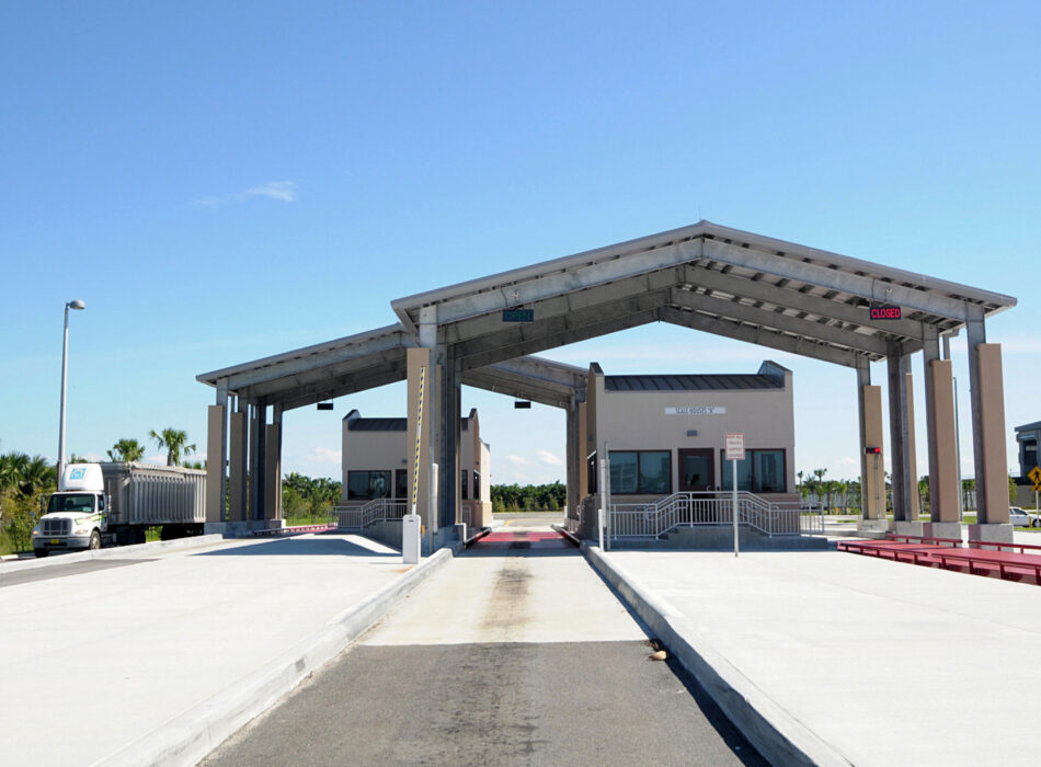 Customs checkpoint with truck, two lanes, and clear sky.