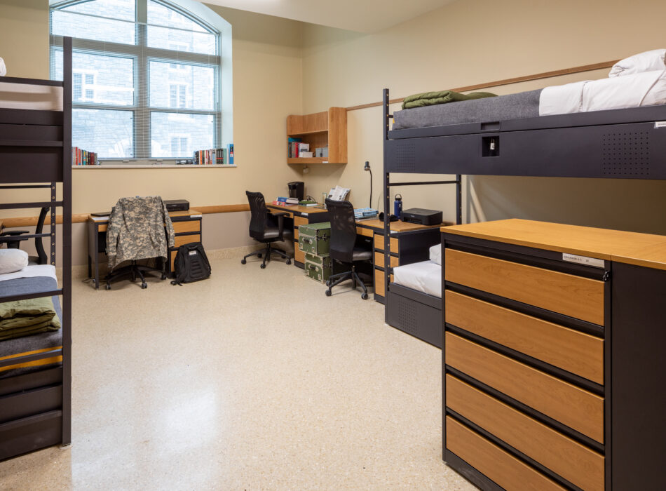 Neat dorm room with lofted beds, desks, and window.