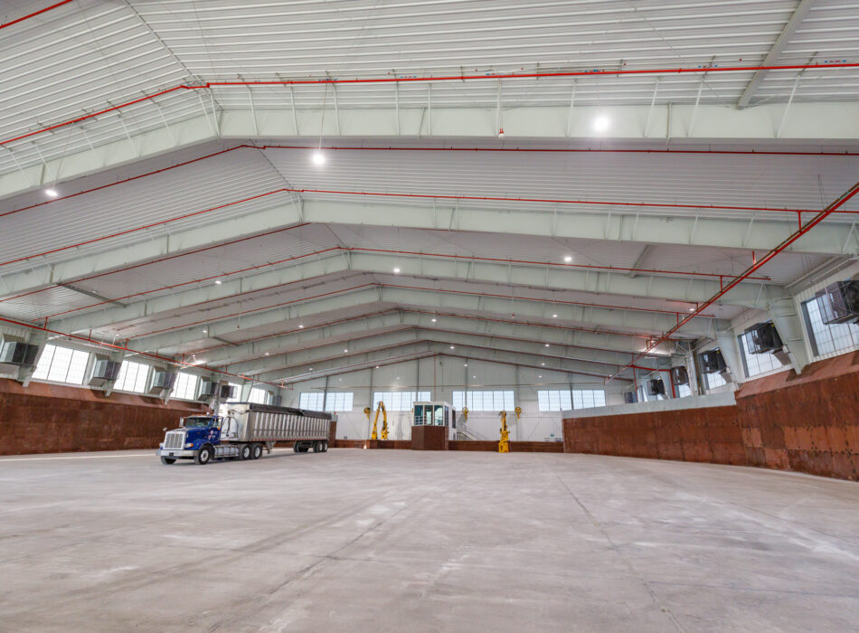 Empty warehouse with parked truck and two yellow machines.