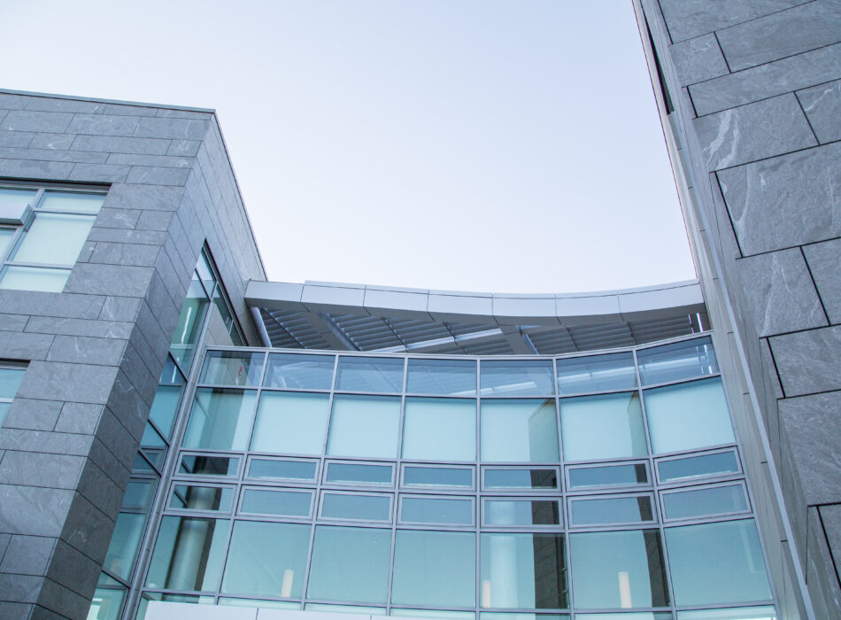 Glass and stone building with large windows, photographed from below.
