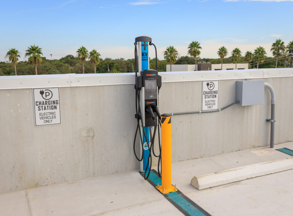 EV charging station on rooftop with palm trees nearby.