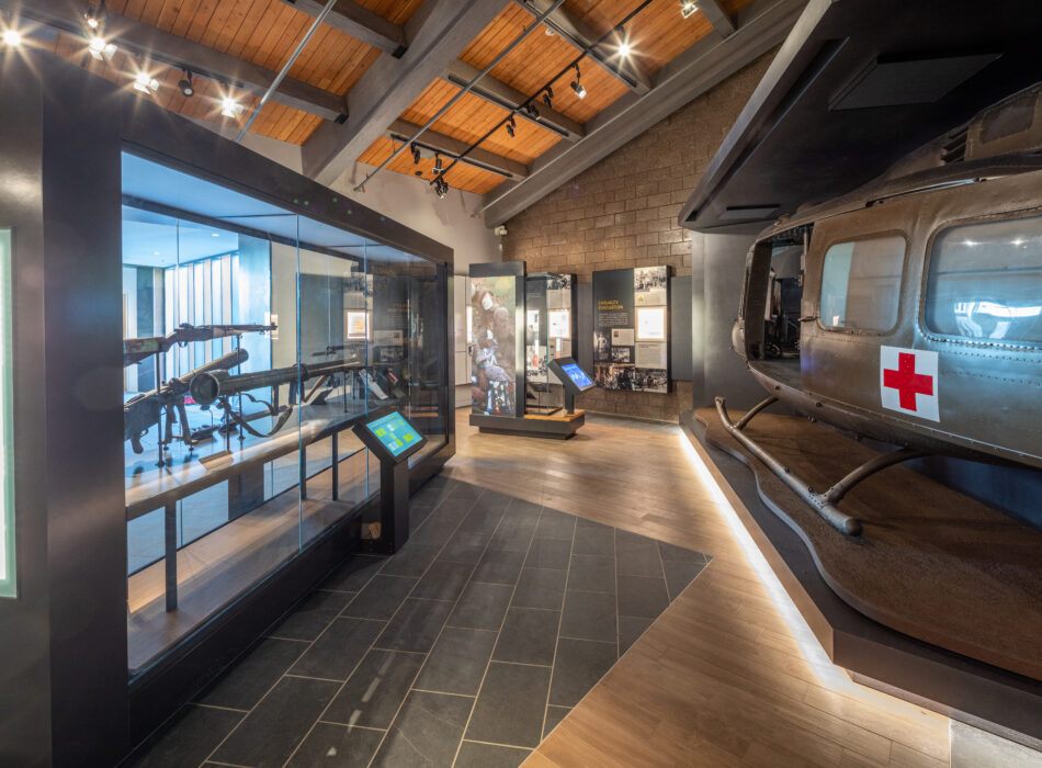 Museum exhibit with weapons, artifacts, and medical helicopter.
