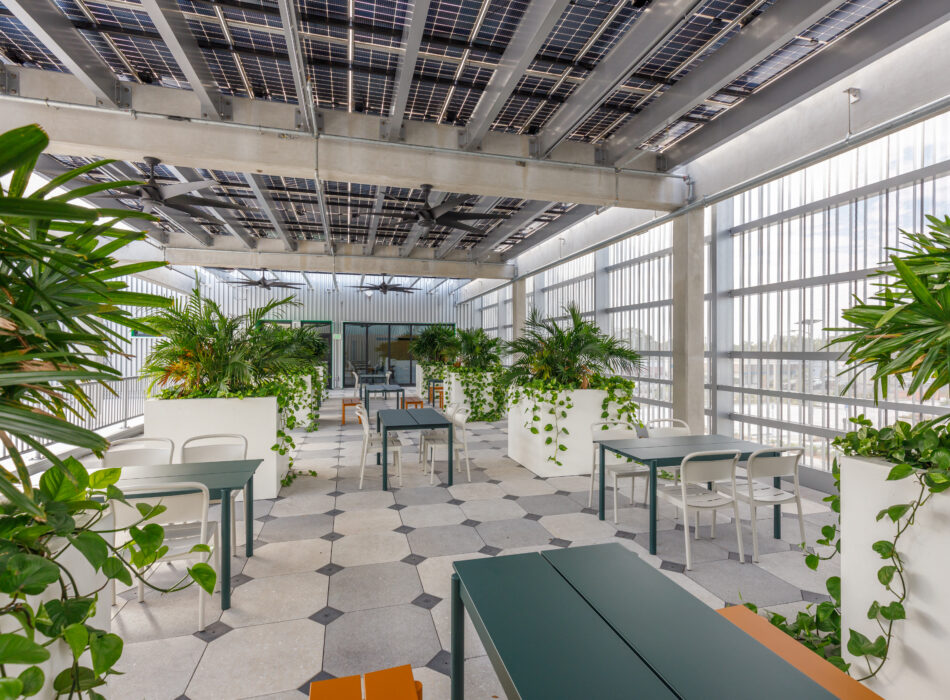 Modern seating area with tables, plants, and solar panel ceiling.