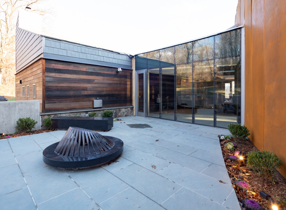 Modern building with wood, glass, concrete, sculpture, and courtyard.