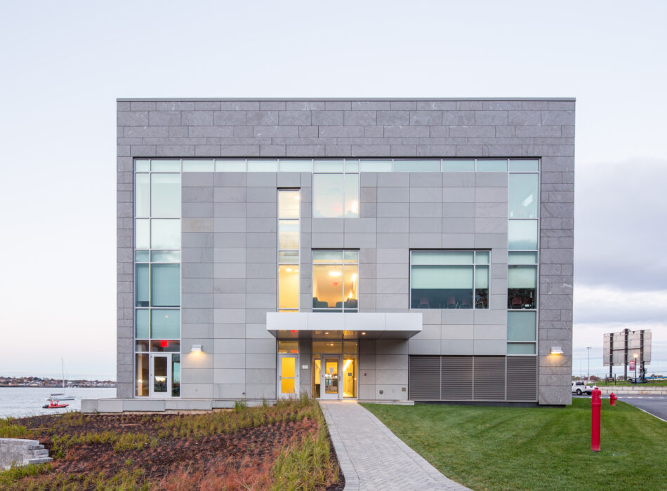 Three-story office building with large windows at dusk.